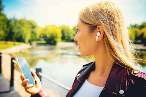 Frau hört Musik über Bluetooth-Kopfhörer