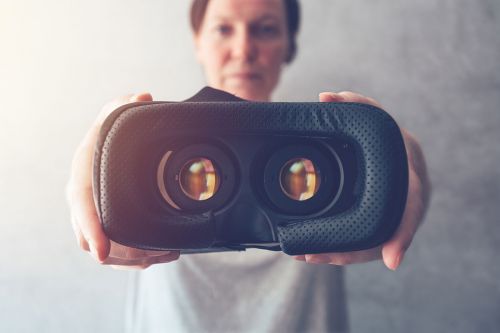 Frau hält VR-Brille in Kamera