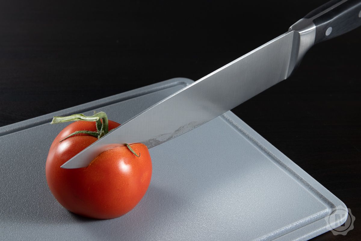 Messer schneidet durch Tomate