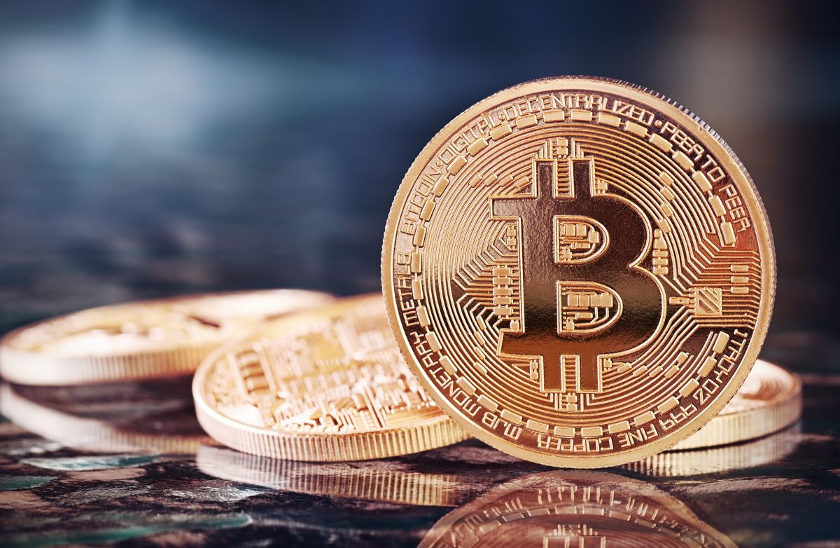Bitcoin-Münze auf dem Rand stehend vor gekippten Münzen