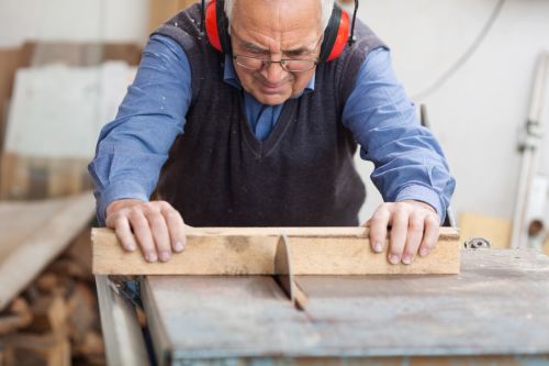Schreiner sägt Holzscheitel mit Tischkreissäge