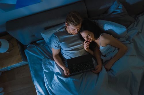 gaming laptop paerchen streamt etwas im bett