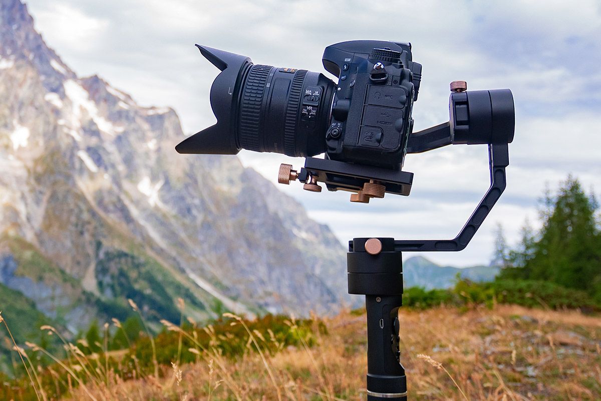 spiegelreflexkamera auf gimbal aufgesetzt vor bergpanaorama
