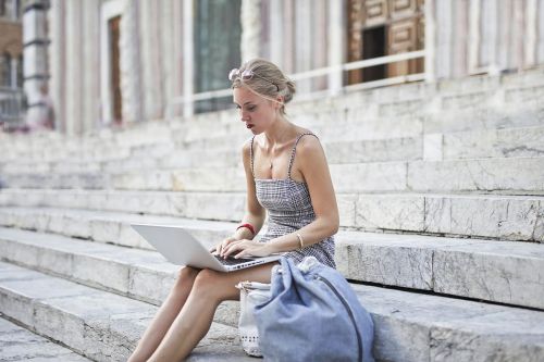 junge Frau sitzt im Freien auf Treppe