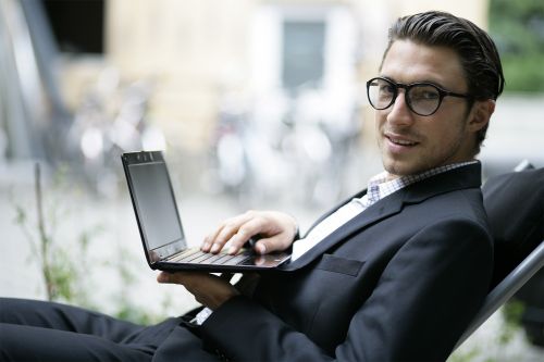 Mann im Liegestuhl mit Netbook