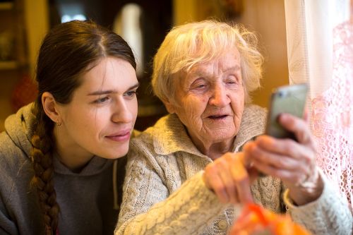 ältere Dame zeigt Frau etwas auf ihrem Smartphone