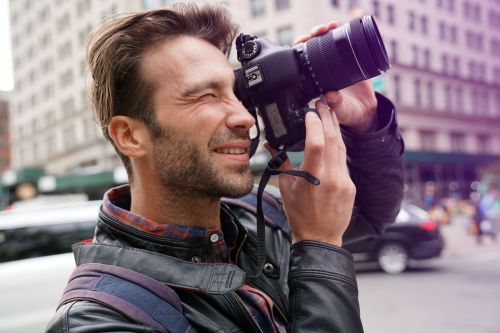 Mann fotografiert mit Systemkamera