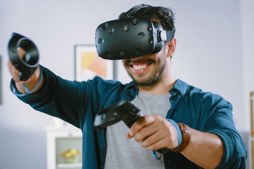 Mann in Wohnzimmer spielt mit VR-Brille