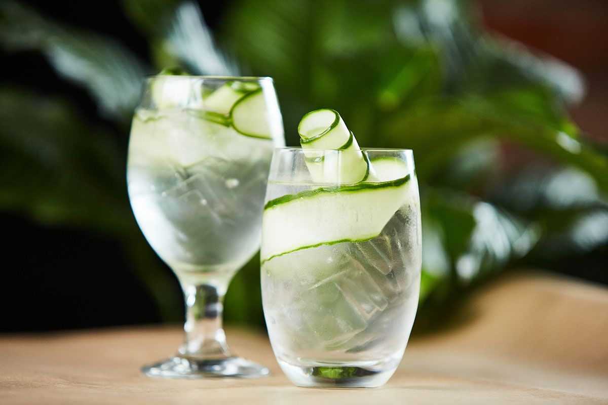 gin in zwi verschiedenen glaesern mit gurkengarnitur
