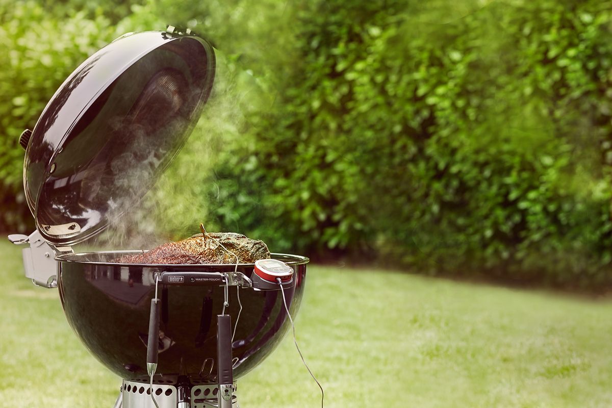 kugelgrill im garten brutzelt fleisch