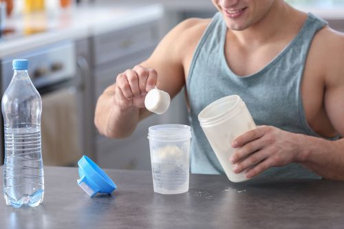 Sportlicher mann mischt sich mit eiweisspulver ein proteinshake