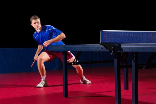 Junger Mann spielt Tischtennis in Halle