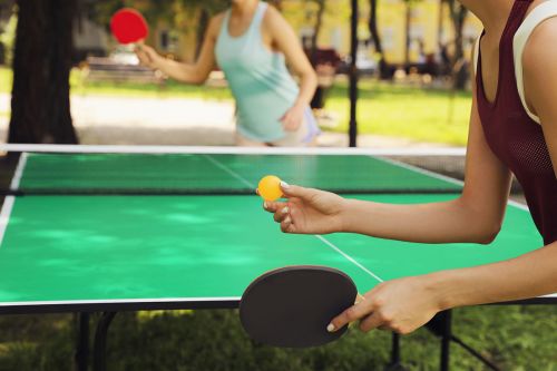 zwei Frauen spielen draußen Tischtennis