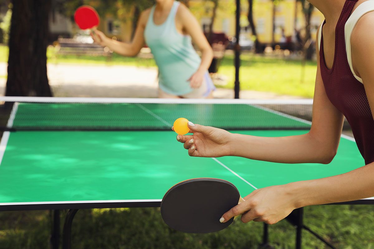 zwei Frauen spielen Tischtennis im Freien