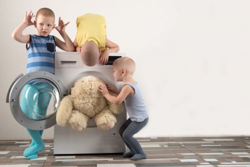Kinder spielen mit Waschmaschine