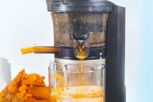Slow Juicer beim Entsaften von Karotten