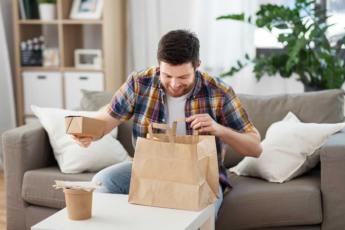 Mann packt Lieferessen aus