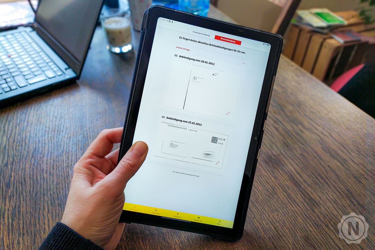 Eine Hand hält ein Tablet mit der Briefankündigung in der Post-&-DHL-App