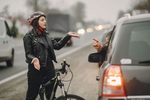 Fahrradfahrerin und Autofahrer streiten