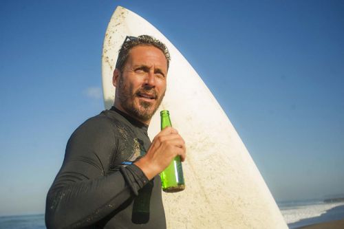 Surfer mit Bier am Strand