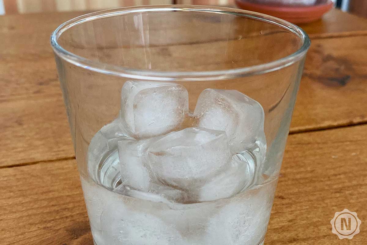 Glas mit Eiswuerfeln und kaltem Wasser