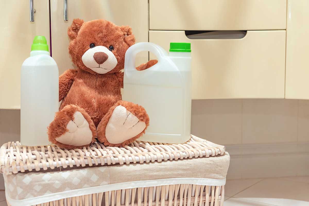 Teddybaer in Waschkueche mit Waschmittel