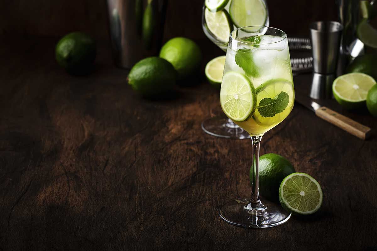 Cocktail mit Limonen auf Holztisch