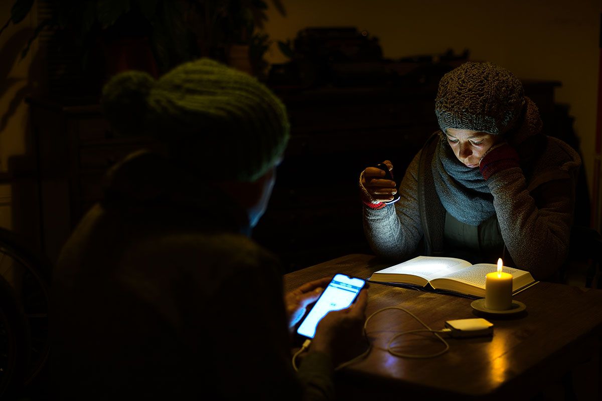 Frau liest ein Buch mit einer Taschenlampe