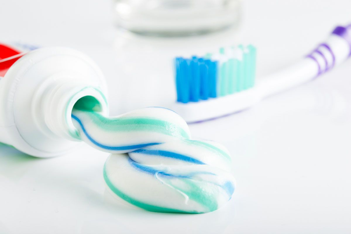 gestreifte zahnpasta wird aus tube gedrückt